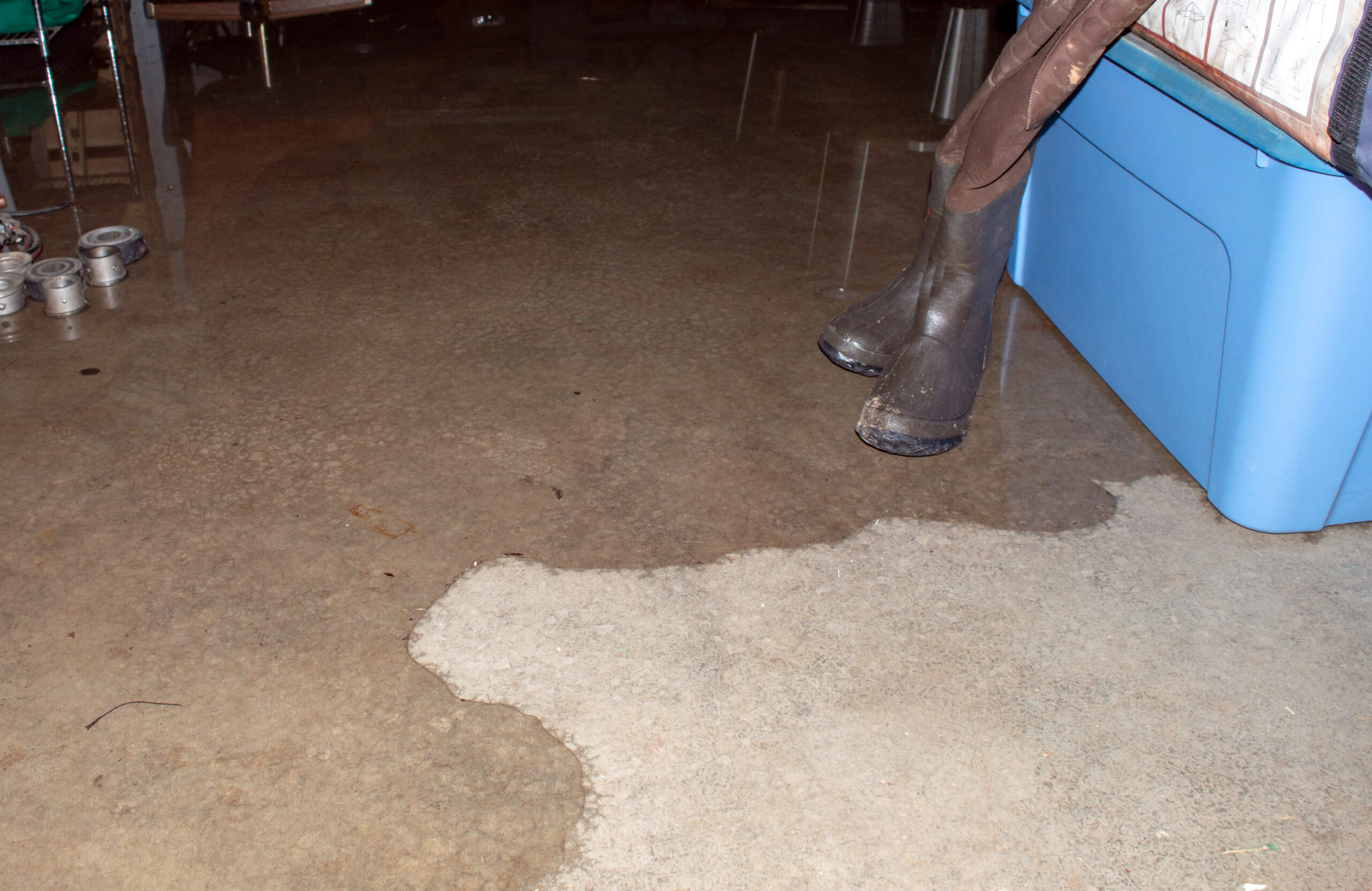 A pair of hip boots stand ready as the basement begins to flood and rains continue to pour down relentlessly. Bokeh